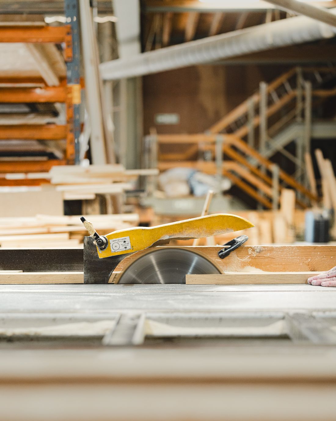 Timber passing through a guarded circular saw in a workshop